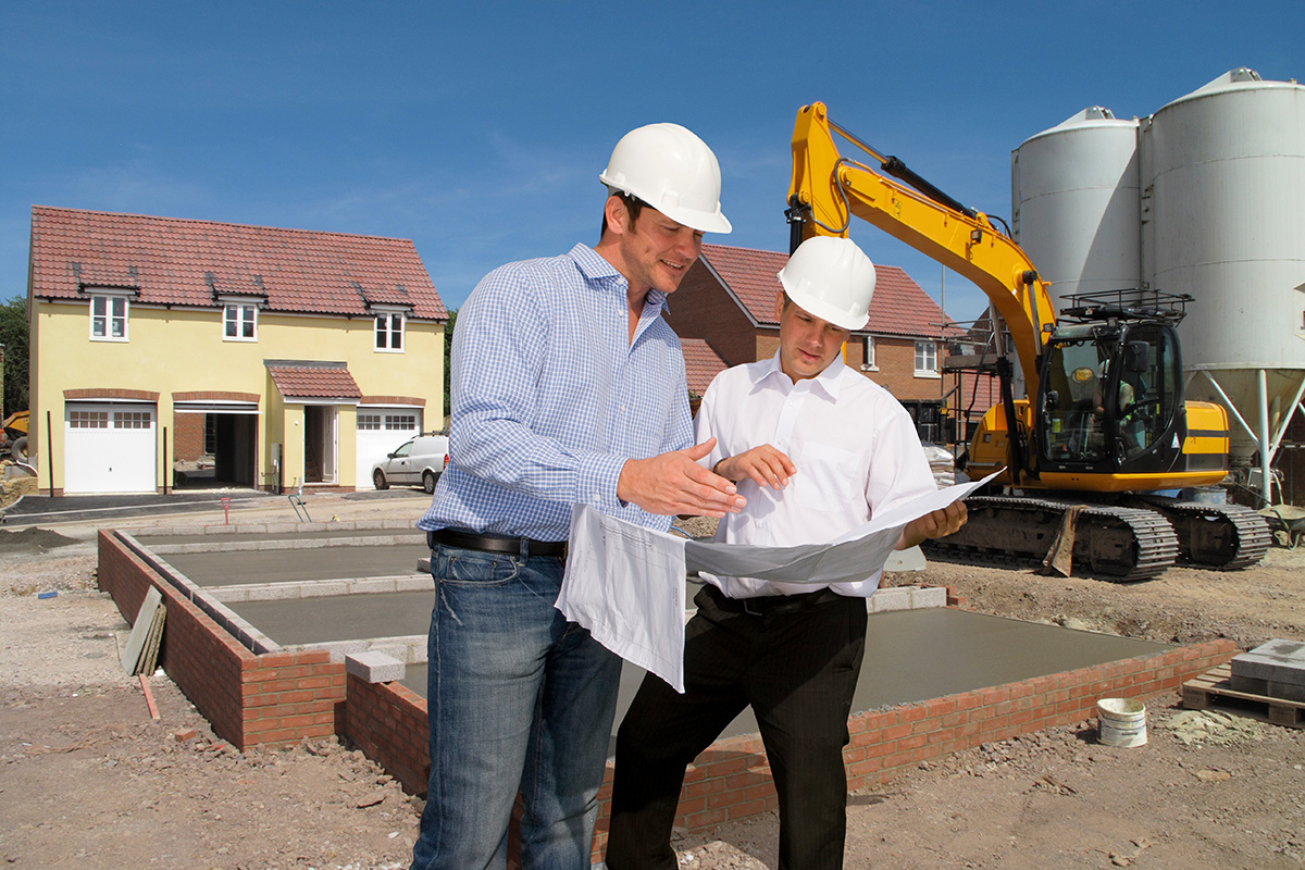 construction workers discussing plans on house