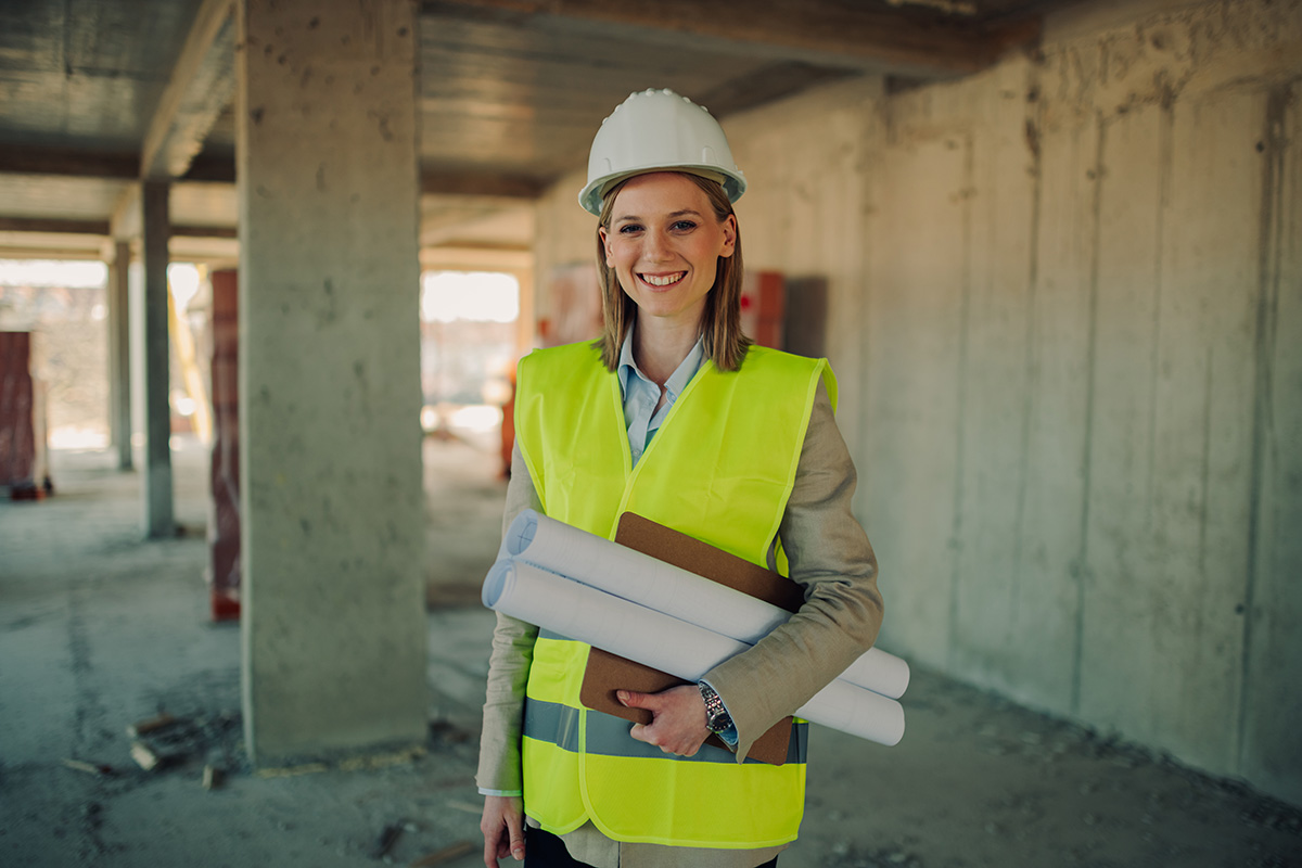 smiling female architect holding blueprints